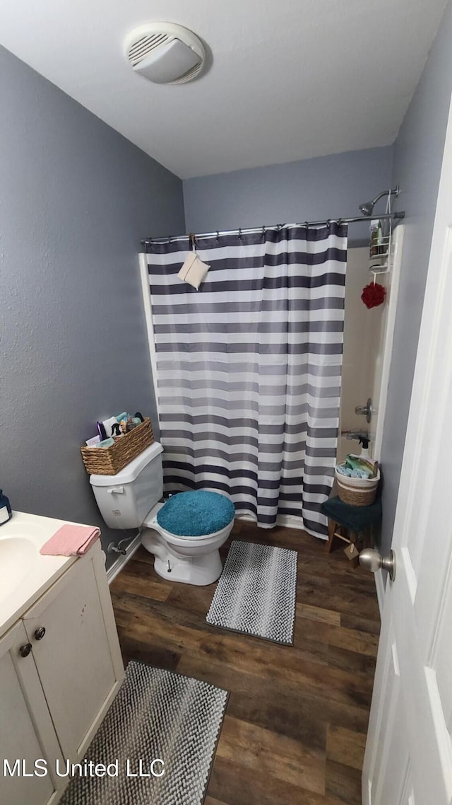 full bathroom with vanity, a shower with shower curtain, wood finished floors, and toilet