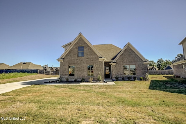 view of front of home with a front yard, fence, and brick siding