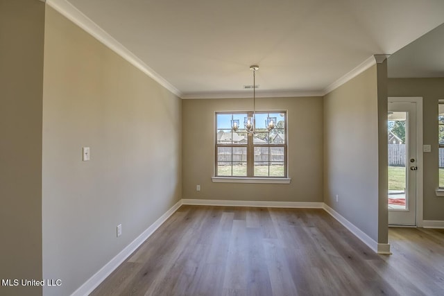 unfurnished dining area with a notable chandelier, light hardwood / wood-style flooring, and ornamental molding