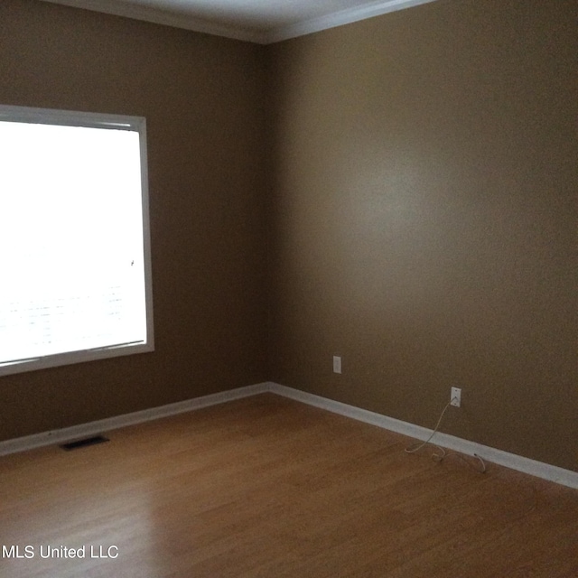 spare room featuring crown molding and hardwood / wood-style flooring