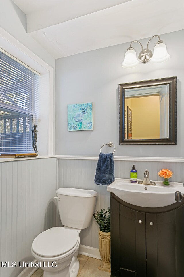 bathroom featuring wood walls, vanity, toilet, and tile patterned flooring