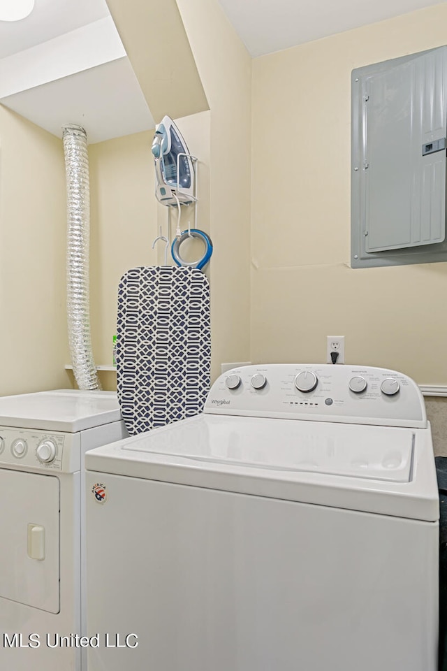 laundry room with electric panel and washing machine and clothes dryer