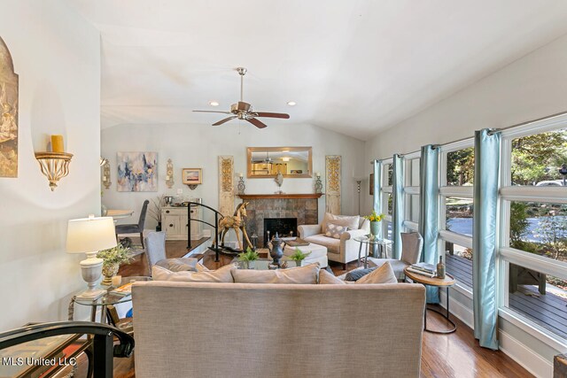 living room with vaulted ceiling, ceiling fan, a fireplace, and dark hardwood / wood-style flooring