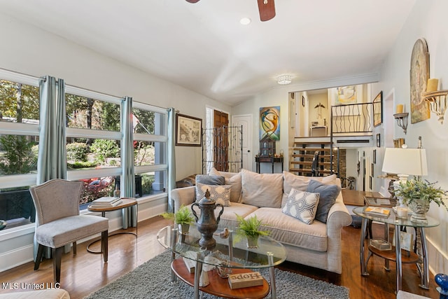 living room with lofted ceiling, hardwood / wood-style flooring, and ceiling fan