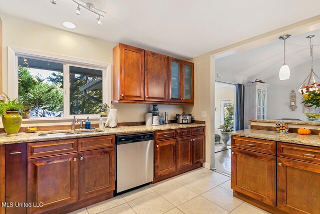 kitchen featuring hanging light fixtures, light stone countertops, dishwasher, light tile patterned flooring, and sink