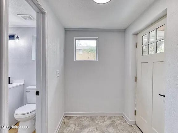 doorway to outside with visible vents and baseboards