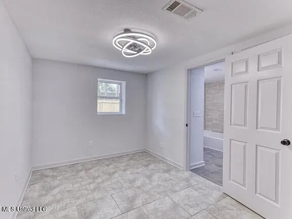 unfurnished bedroom with baseboards and visible vents