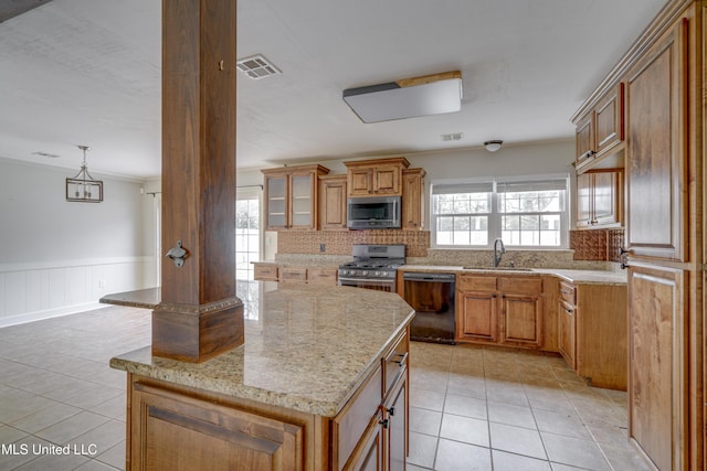 kitchen featuring sink, appliances with stainless steel finishes, a kitchen island, and a wealth of natural light