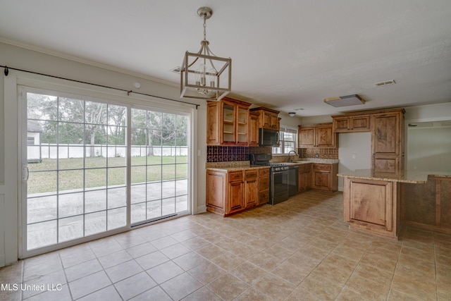 kitchen featuring black gas range oven, sink, backsplash, decorative light fixtures, and light stone countertops