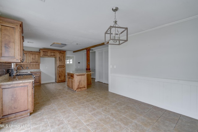 kitchen with hanging light fixtures, a kitchen island, light stone counters, and backsplash