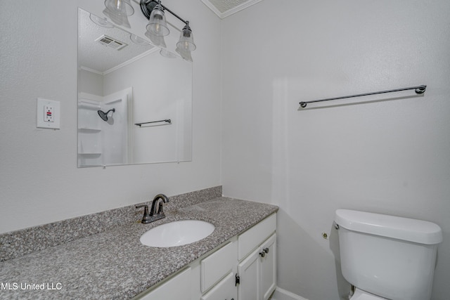 bathroom featuring toilet, crown molding, vanity, and walk in shower