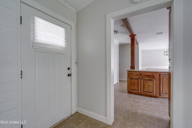 tiled foyer entrance featuring crown molding