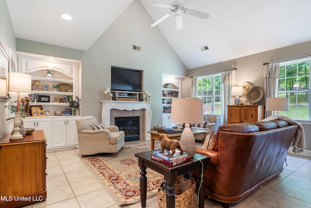 2038 Nottaway Dr, Southaven, MS 38672 - living room featuring built in features, high vaulted ceiling, a tile fireplace, light tile patterned floors, and a ceiling fan