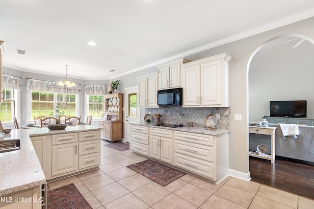 2038 Nottaway Dr, Southaven, MS 38672 - kitchen featuring black appliances, light tile patterned floors, healthy amount of natural light, backsplash, and ornamental molding
