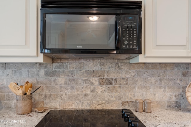 2038 Nottaway Dr, Southaven, MS 38672 - kitchen view of black microwave, backsplash, white cabinetry, and light stone counters