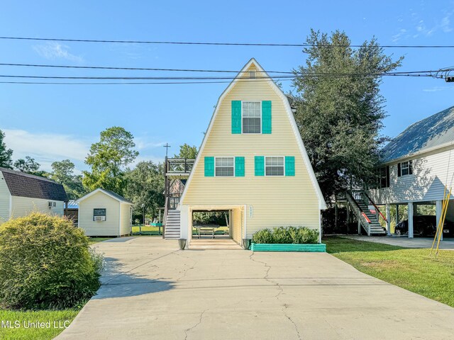 6085 Apache Dr, Kiln, MS 39556 - a-frame style home featuring a gambrel roof, driveway, and stairway