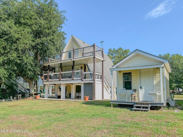 6085 Apache Dr, Kiln, MS 39556 - view of front of house with a balcony, a front yard, and covered porch