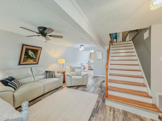 6085 Apache Dr, Kiln, MS 39556 - living area with wood finished floors, a textured ceiling, ceiling fan, and stairs