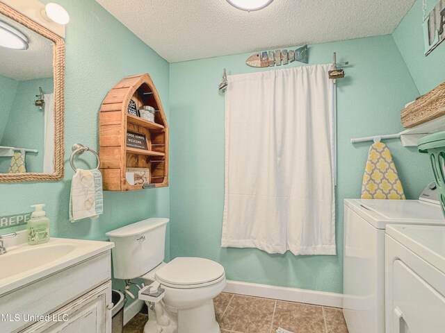 6085 Apache Dr, Kiln, MS 39556 - bathroom with vanity, toilet, baseboards, a textured ceiling, and separate washer and dryer