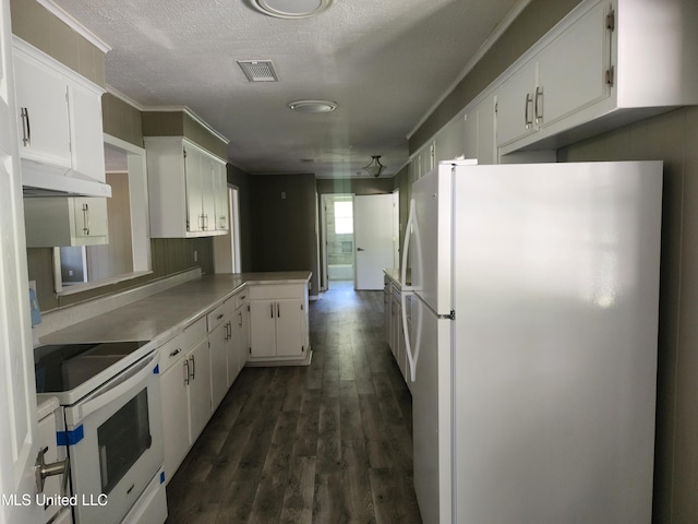 kitchen with dark wood-type flooring, white cabinets, kitchen peninsula, and white appliances