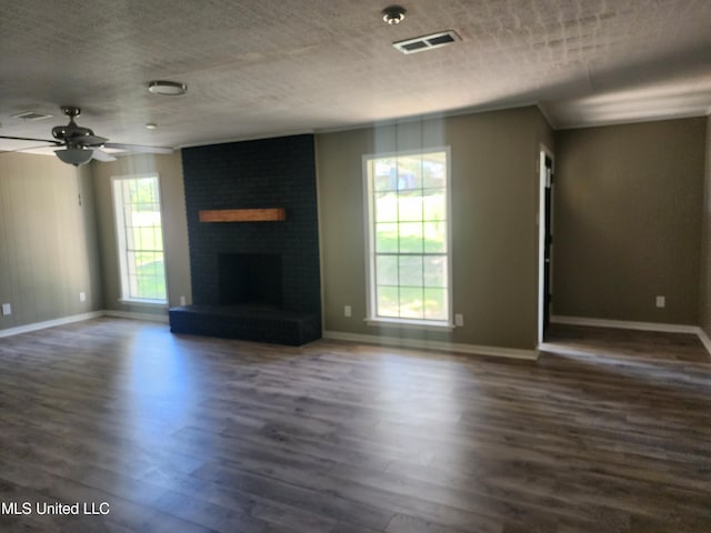 unfurnished living room with a textured ceiling, ceiling fan, a fireplace, and dark hardwood / wood-style flooring