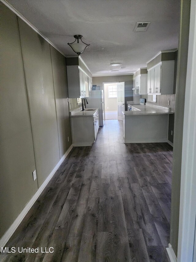 kitchen featuring white cabinetry, a textured ceiling, white appliances, and dark hardwood / wood-style flooring