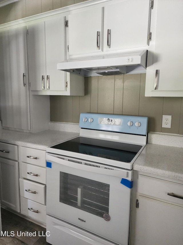 kitchen featuring exhaust hood, white electric range, and white cabinetry