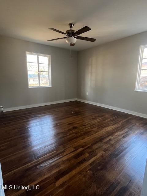 spare room with ceiling fan and dark hardwood / wood-style floors