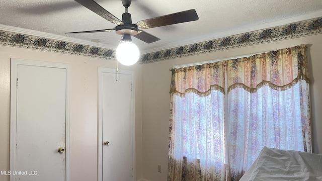 room details featuring ceiling fan, ornamental molding, and a textured ceiling