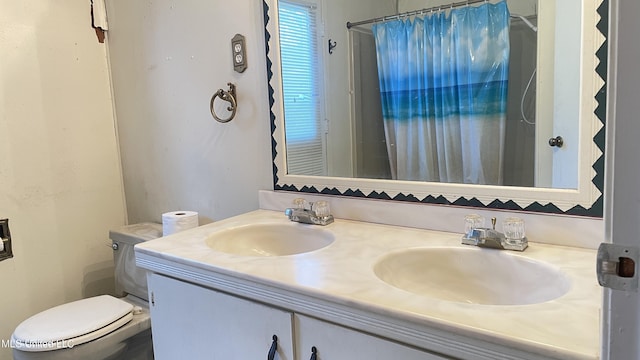 bathroom with vanity, curtained shower, and toilet