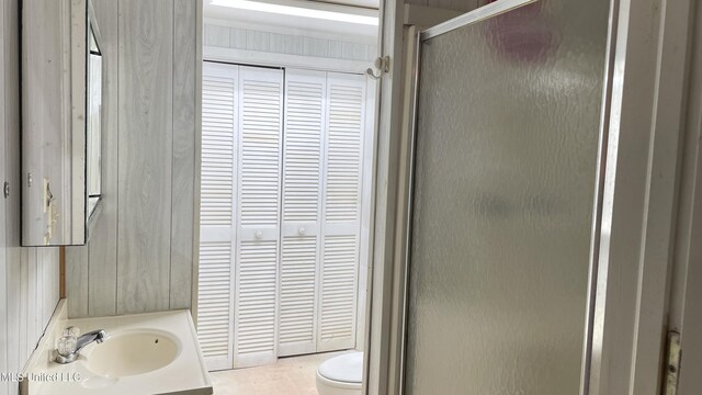 bathroom with a shower with door, vanity, and toilet