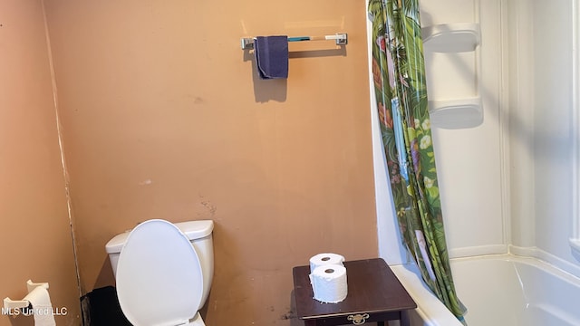 bathroom featuring shower / tub combo and toilet