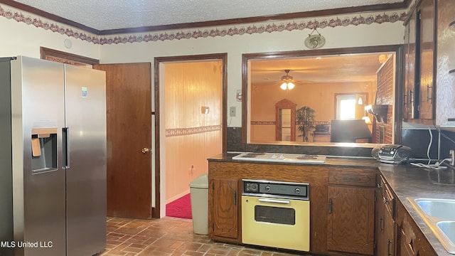 kitchen with ceiling fan, wall oven, stainless steel fridge with ice dispenser, white gas stovetop, and a textured ceiling