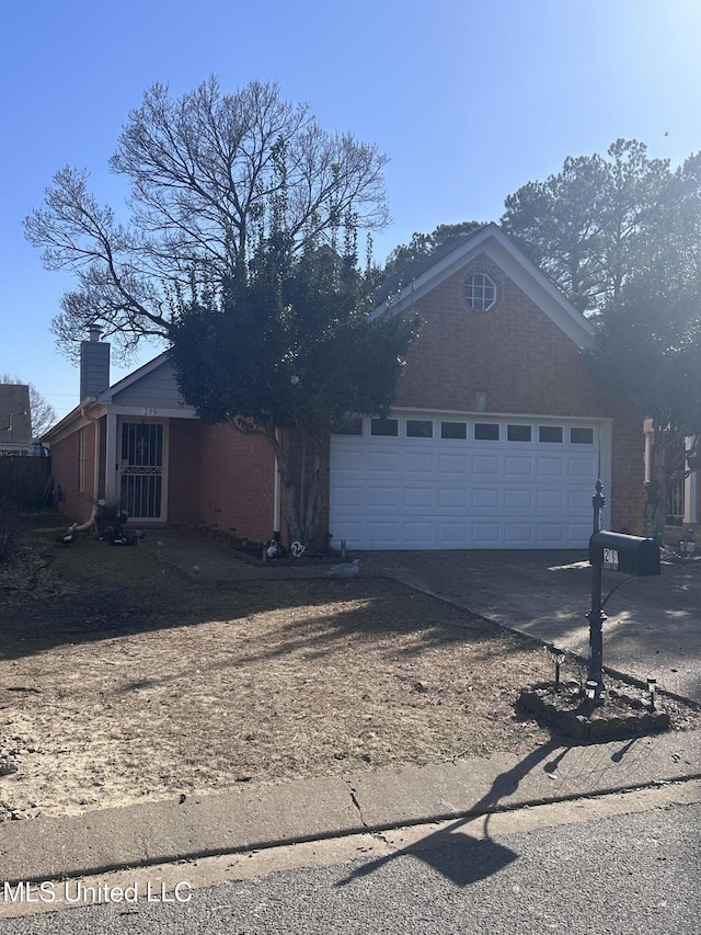 ranch-style home featuring a chimney, driveway, and an attached garage