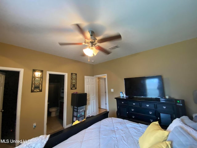 bedroom featuring connected bathroom, ceiling fan, and a walk in closet