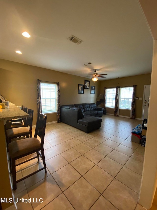 living room with ceiling fan, light tile patterned floors, and plenty of natural light