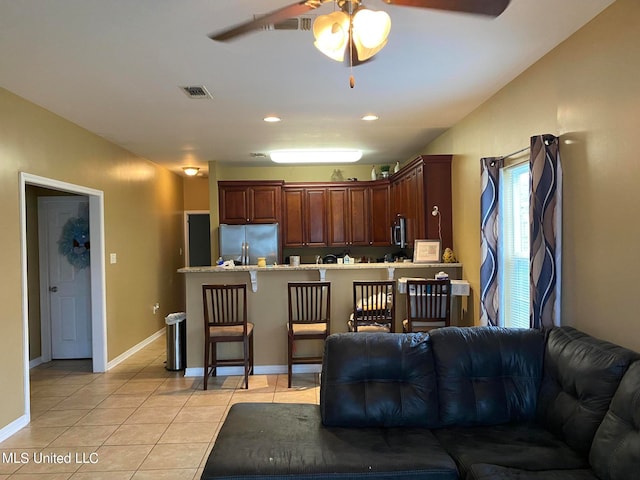 living room with ceiling fan and light tile patterned floors