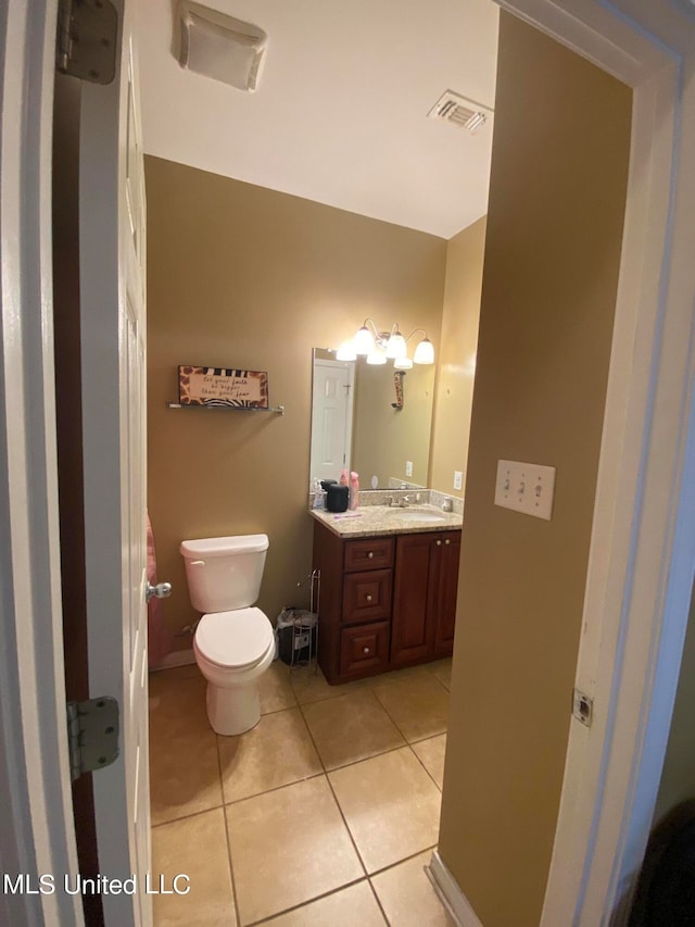 bathroom with vanity, toilet, and tile patterned floors