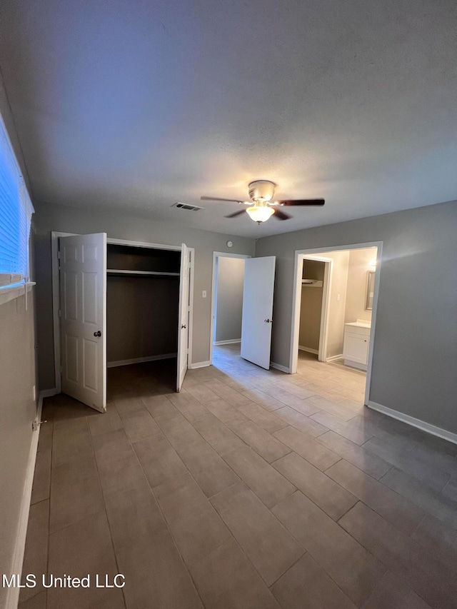 unfurnished bedroom featuring ceiling fan and ensuite bathroom