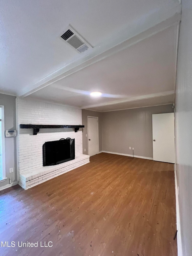 unfurnished living room with a brick fireplace and hardwood / wood-style flooring