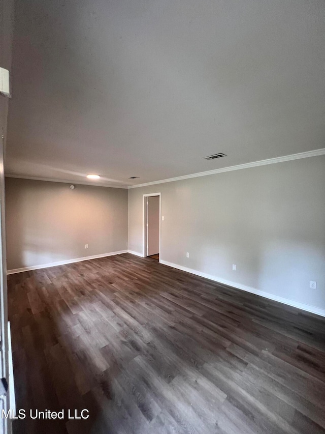 empty room with dark wood-type flooring and ornamental molding