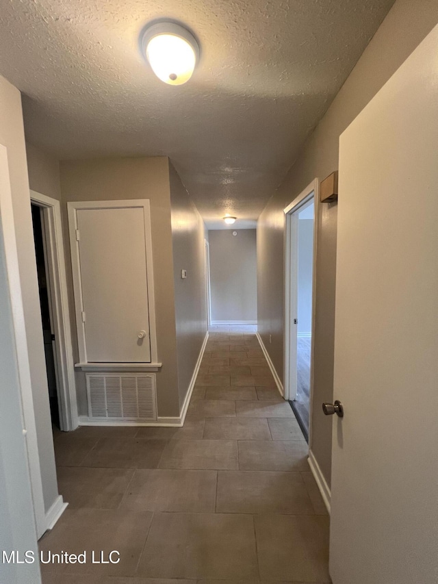 4224 Cypress Dr, Jackson, MS 39212 - hall featuring a textured ceiling, tile patterned flooring, and baseboards