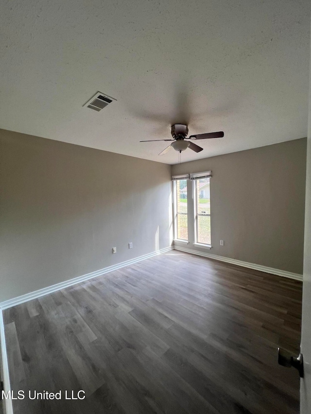 spare room featuring ceiling fan, dark hardwood / wood-style floors, and a textured ceiling