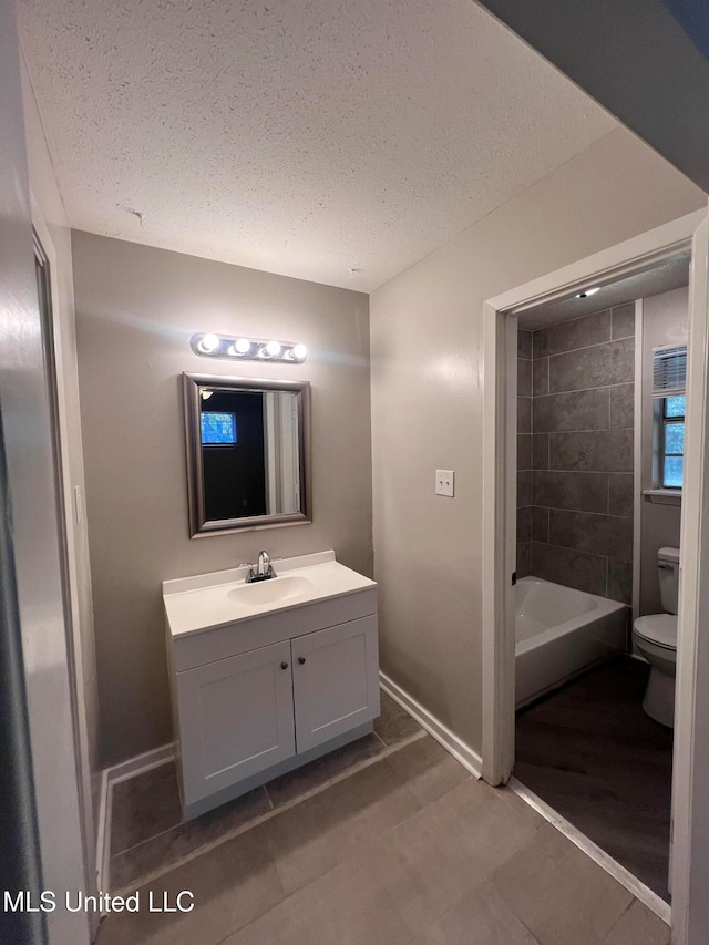 bathroom featuring vanity, a textured ceiling, and toilet