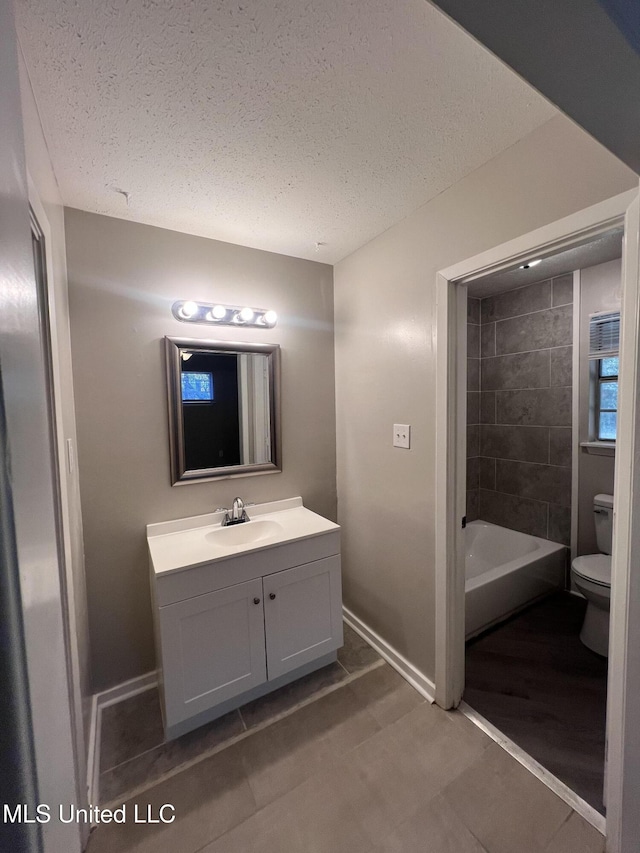 4224 Cypress Dr, Jackson, MS 39212 - bathroom with toilet, baseboards, vanity, a textured ceiling, and tile patterned flooring