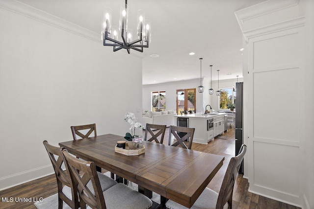 dining room with sink, crown molding, and dark hardwood / wood-style flooring