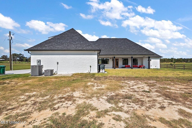 rear view of house featuring central air condition unit, a patio, and a yard