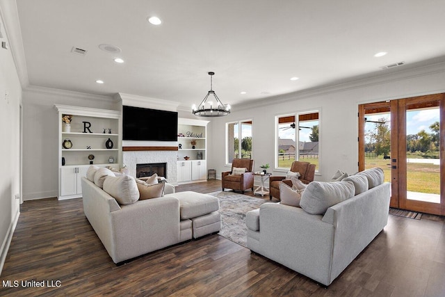 living room featuring ornamental molding, dark hardwood / wood-style flooring, and a chandelier