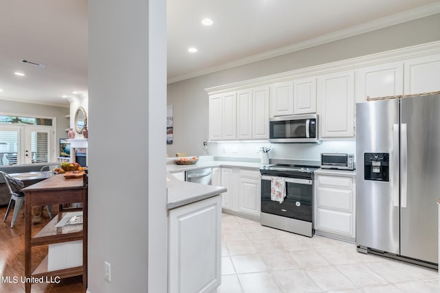 kitchen featuring crown molding, white cabinetry, and stainless steel appliances