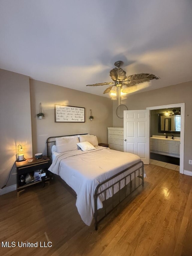 bedroom with light wood-type flooring, ensuite bath, a ceiling fan, and baseboards